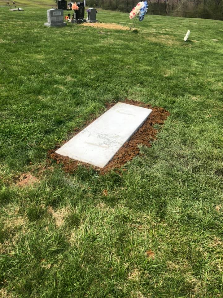 Cemetery grounds overview showing flat grave markers and headstones across the lawn